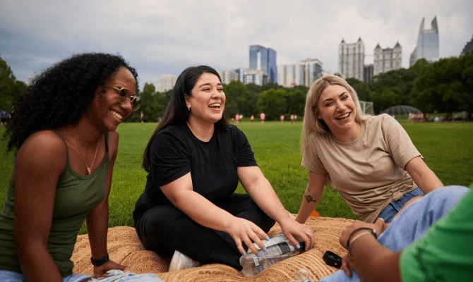 TurboTax customer Vanessa laughs outdoors with her friends.