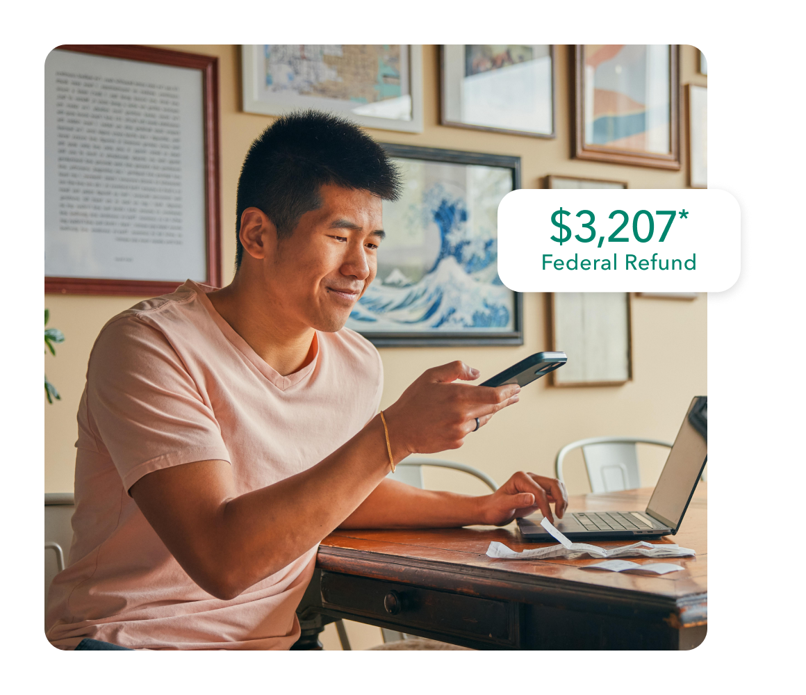 TurboTax customer Hubert smiles as he uses his phone to upload his tax docs.