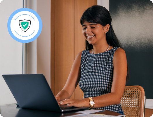 TurboTax customer Elizabeth is seated with her laptop open, smiling.
