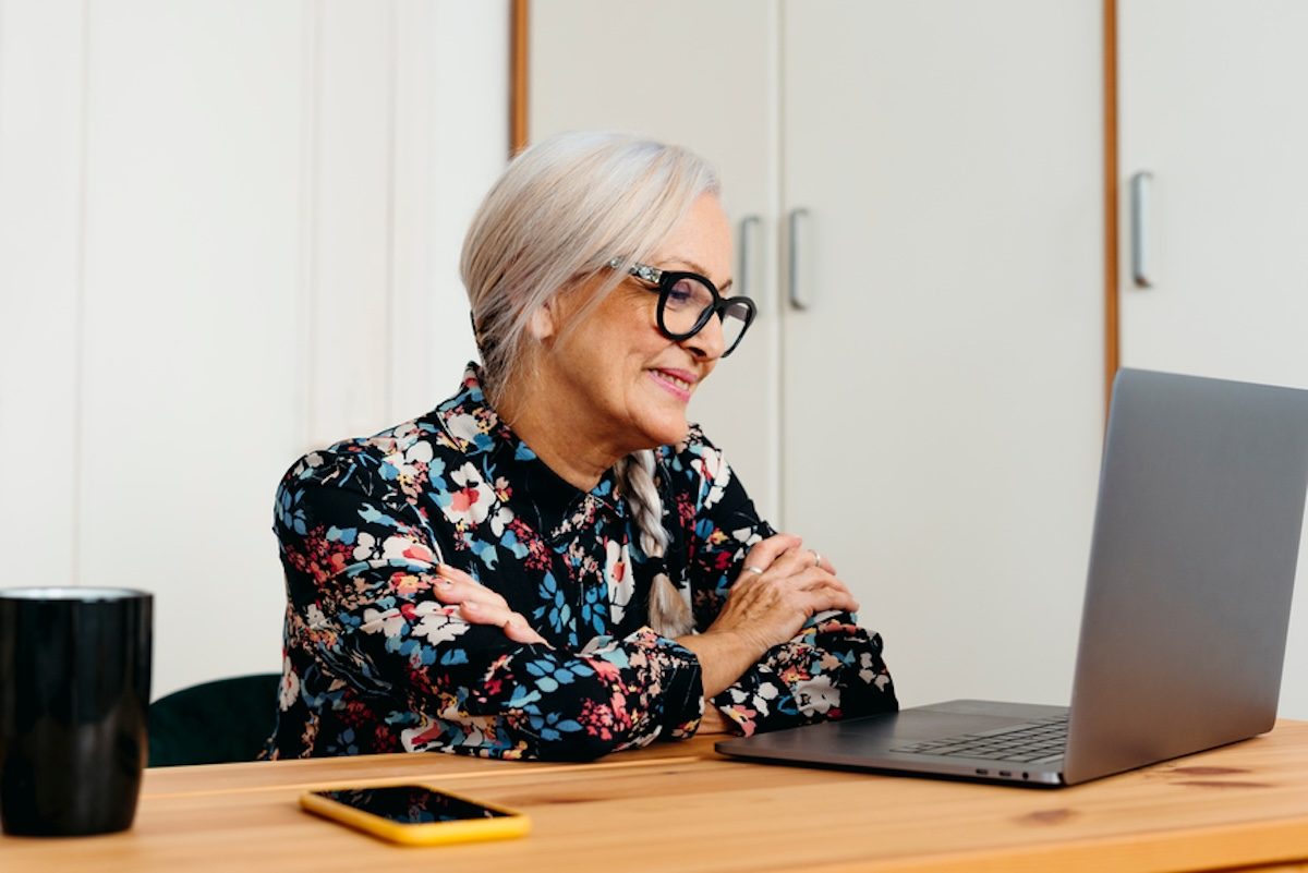 A person sitting at a table with a laptop.