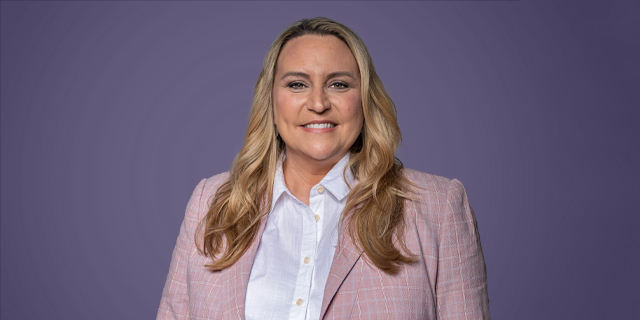 A person in a pink shirt and purple tie.
