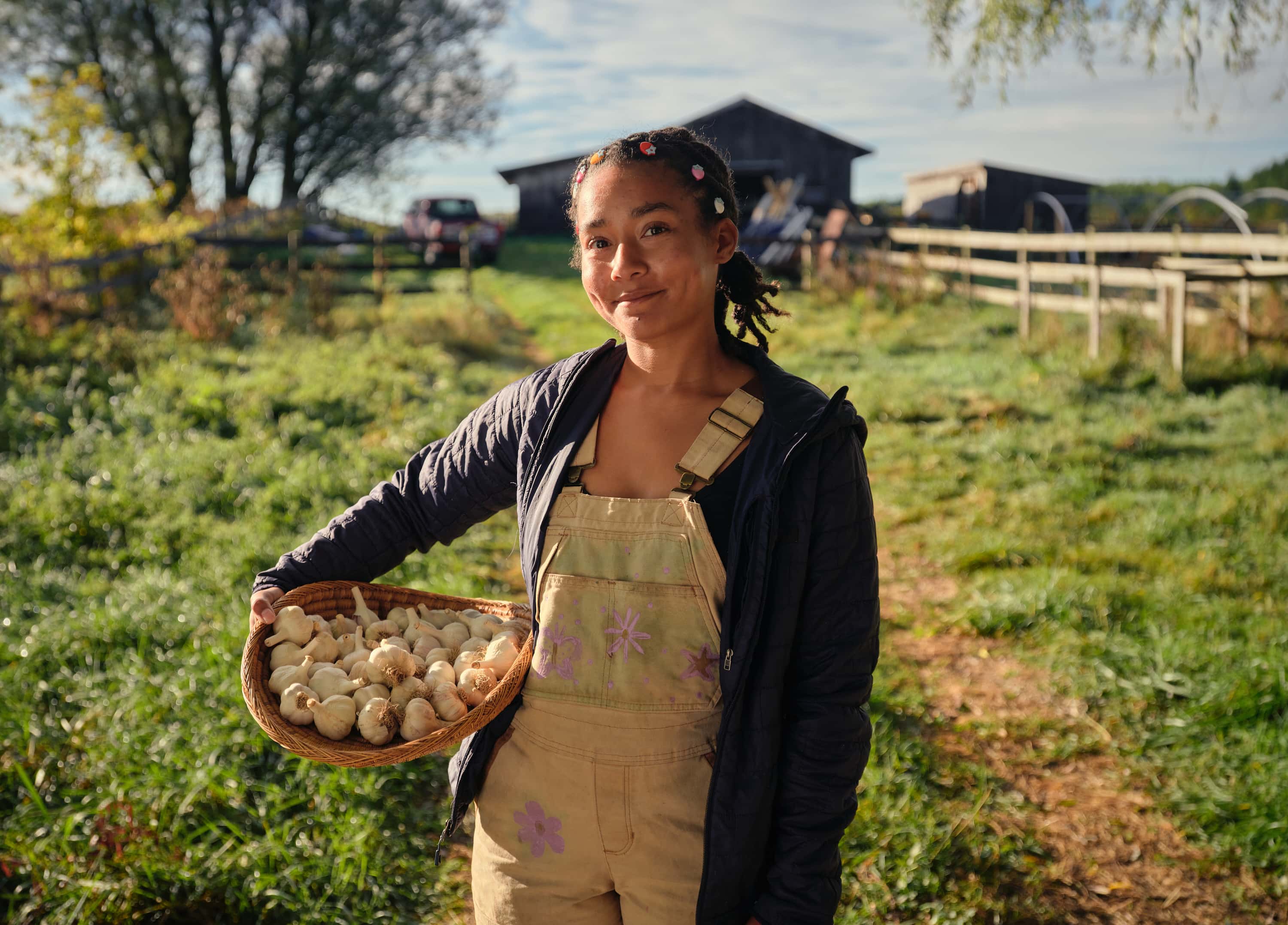Cheyenne Sundance holding a basket of garlic at a farm.